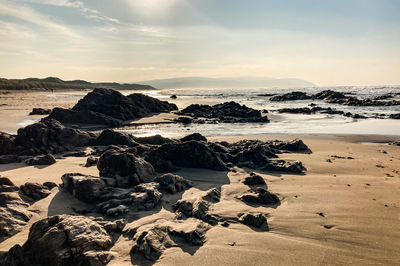 Rocks on beach against sky