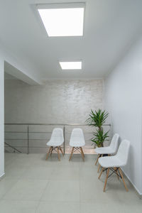 Empty chairs and table against wall in building