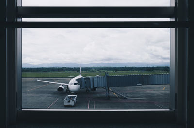 Airplane on runway seen through window