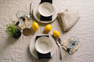 Vintage table setting with linen napkins and yellow lemons.