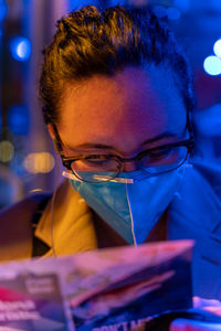 Woman reads a travel guide while wearing covid mask