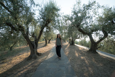 Full length of woman standing amidst trees