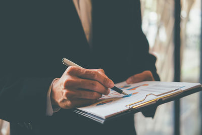 Midsection of businessman working at office