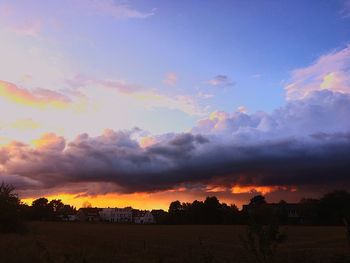 Scenic view of silhouette field against sky at sunset