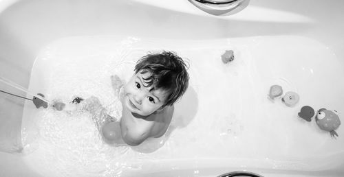 High angle portrait of baby boy sitting in bathtub