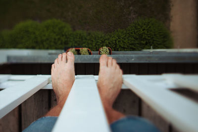 Low section of man standing on railing