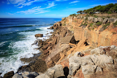 Rock formation on beach against sky