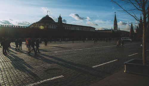 People walking on street in city against sky