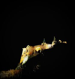 Low angle view of illuminated building against sky at night