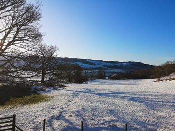 Scenic view of snow covered landscape against clear sky