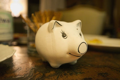 Close-up of white piggy bank on table