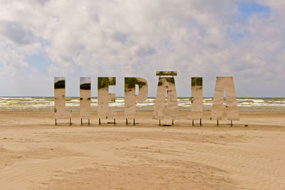 Chairs on beach against sky