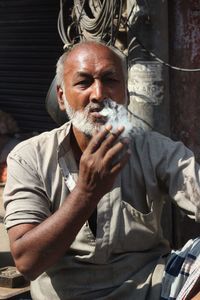 Portrait of man smoking cigarette in city