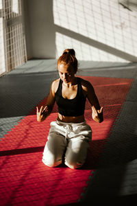 Side view of woman sitting on floor