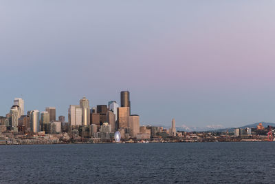 City at waterfront against clear sky