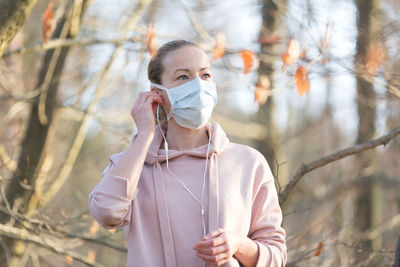 Woman wearing mask standing at park