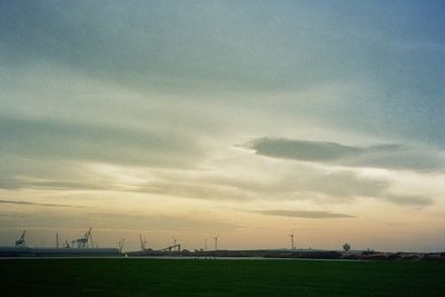 Scenic view of field against cloudy sky