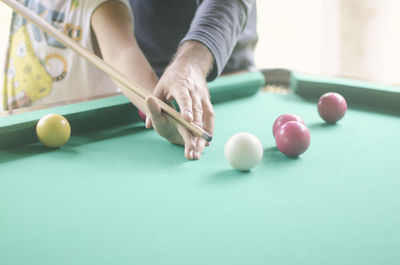 Midsection of people playing pool