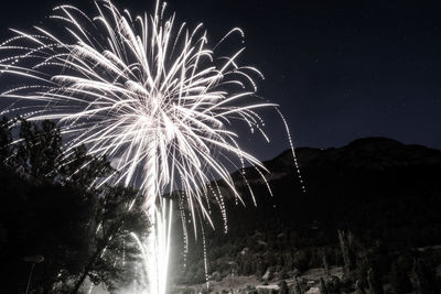 Low angle view of firework display at night