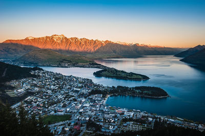 Aerial view of lake and buildings against sky at sunset