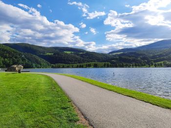 Scenic view of lake by mountains against sky