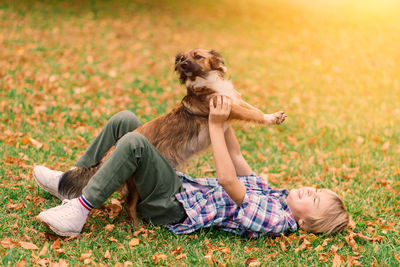 Low section of woman with dog on field