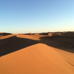 Scenic view of desert against clear blue sky