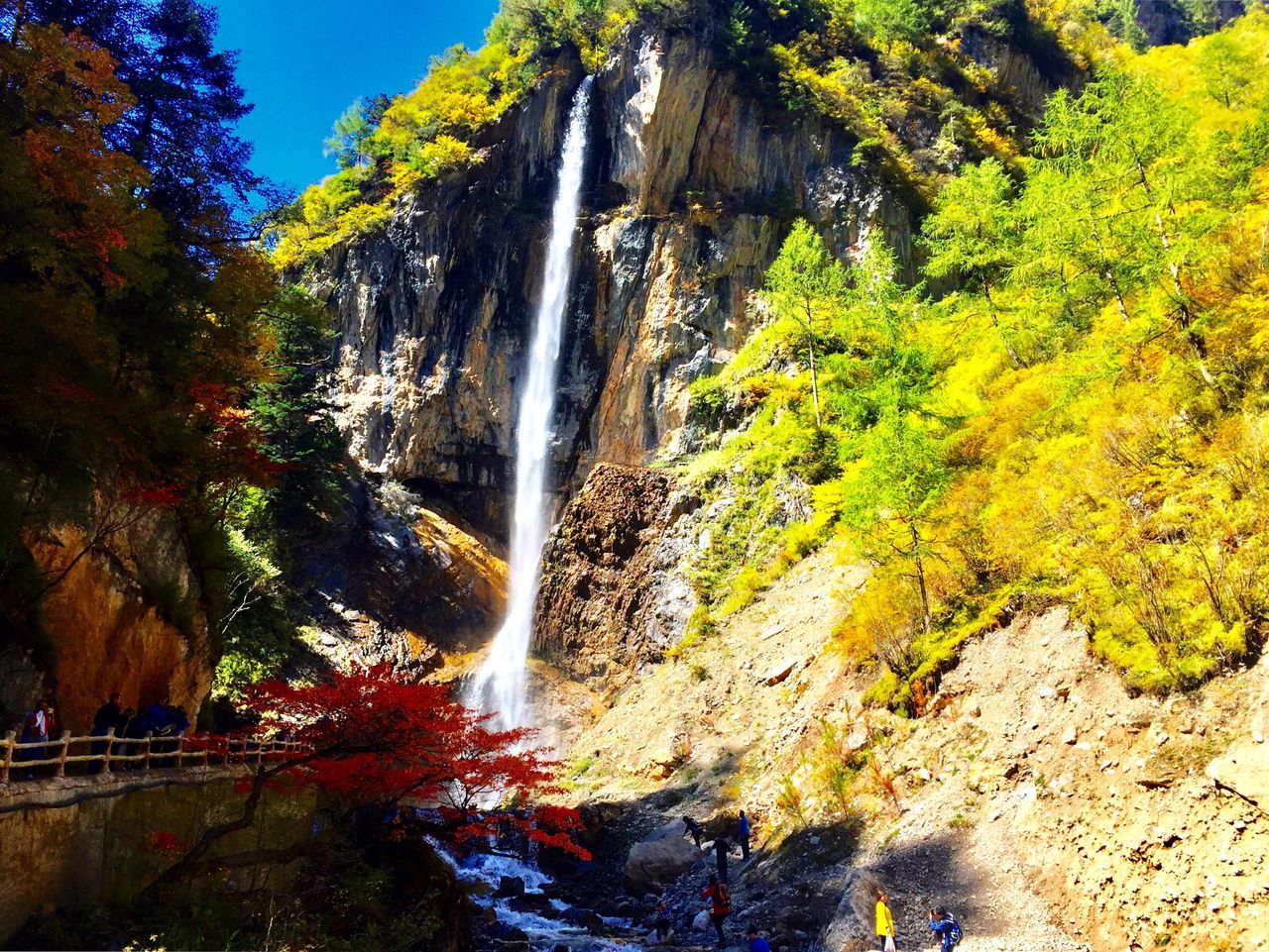 waterfall, tree, water, scenics, beauty in nature, nature, motion, rock formation, tranquil scene, growth, day, majestic, tranquility, non-urban scene, outdoors, flowing, cliff, blue, natural landmark, flowing water, power in nature, falling water, no people