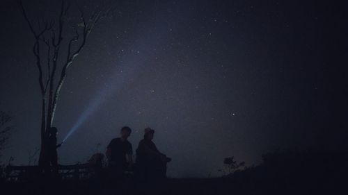 Low angle view of silhouette man against sky at night