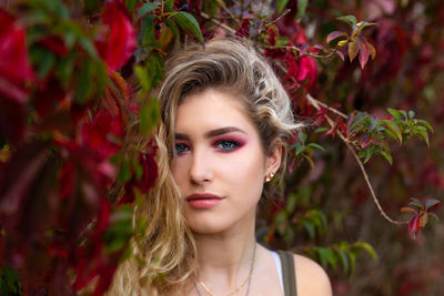 Portrait of beautiful young woman with make-up by plants