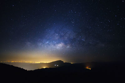 Low angle view of silhouette mountain against sky at night