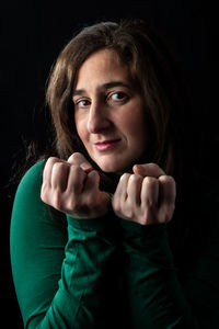 Portrait of smiling woman against black background