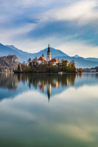 Scenic view of lake by buildings against sky