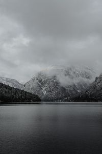 Scenic view of lake by mountains against sky