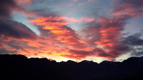 Low angle view of silhouette mountains against romantic sky