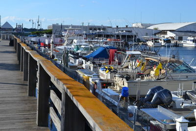 Boats moored at harbor against sky