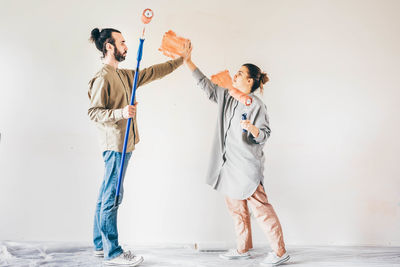 Full length of couple standing against wall