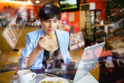 Young woman using mobile phone in cafe