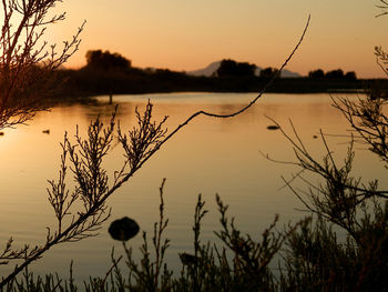 Scenic view of lake against sky at sunset