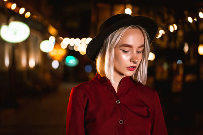 Portrait of young woman looking away at night