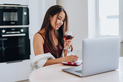 Young woman using mobile phone at home