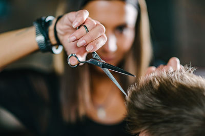 Hairdresser cutting man hair at salon