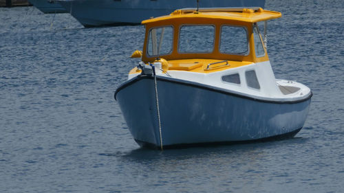 Port side of yellow and white boat  moored in water