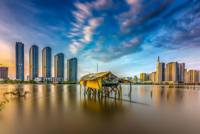 Panoramic view of city buildings against cloudy sky