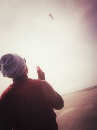 Low angle view of man paragliding against sky