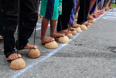 Low section of people standing on coconuts over road
