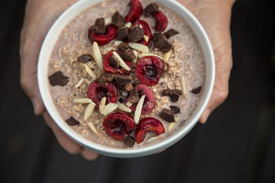 Cropped hands of woman holding fresh breakfast bowl