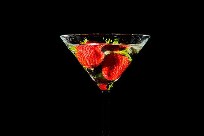 Close-up of red wine glass against black background