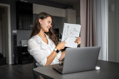 Businesswoman using laptop at home