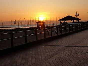 Pier over sea against sky during sunset